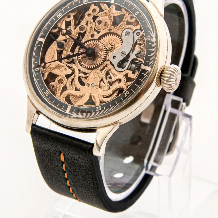 Czarny pasek z pomarańczowym przeszyciem przy zegarku Omega Skeleton Fish – wyrazista kompozycja z detalem vintage