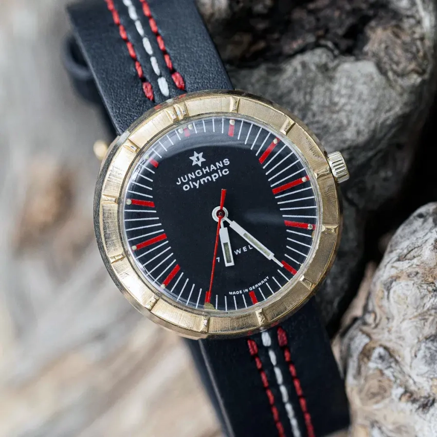 U-80 – czarny pasek ze skóry licowej z czerwono-białym przeszyciem, pokazany przy zegarku Junghans Olympic